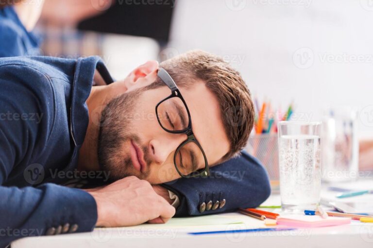 13287344-dormindo-no-trabalho-cansado-jovem-empresario-dormindo-enquanto-esta-sentado-em-seu-local-de-trabalho-e-inclinando-a-cabeca-na-mesa-foto